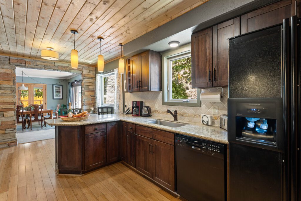 A kitchen with wooden cabinets and wood floors.