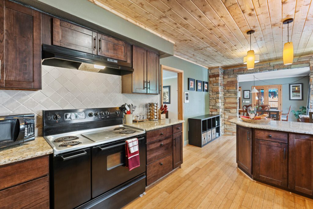 A kitchen with wood floors and wooden cabinets.