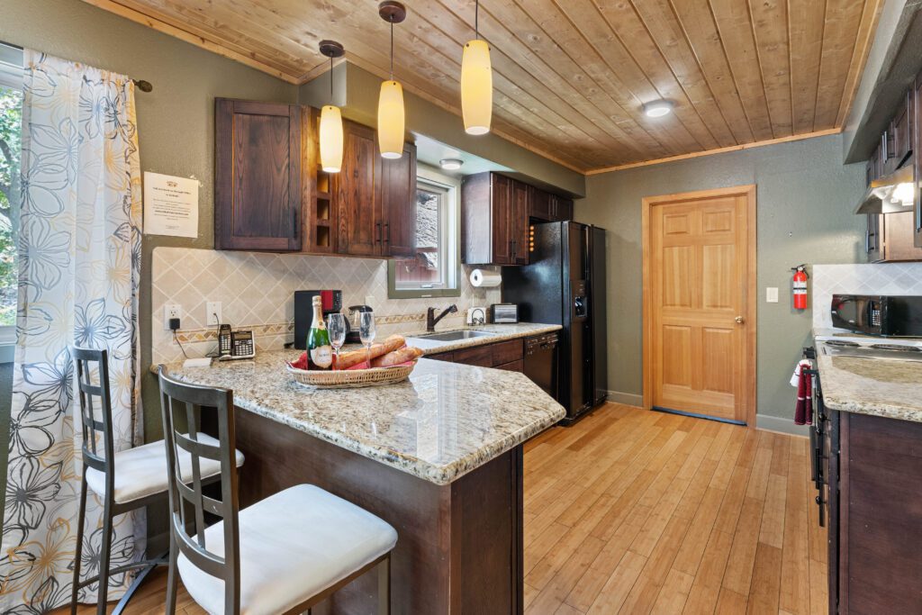 A kitchen with wooden floors and granite counter tops.