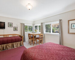 A bedroom with two beds and a dining table.