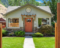 A small house with a clock on the front door.