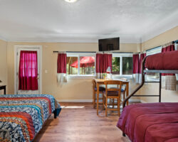 A room with two beds and a tv on the wall.