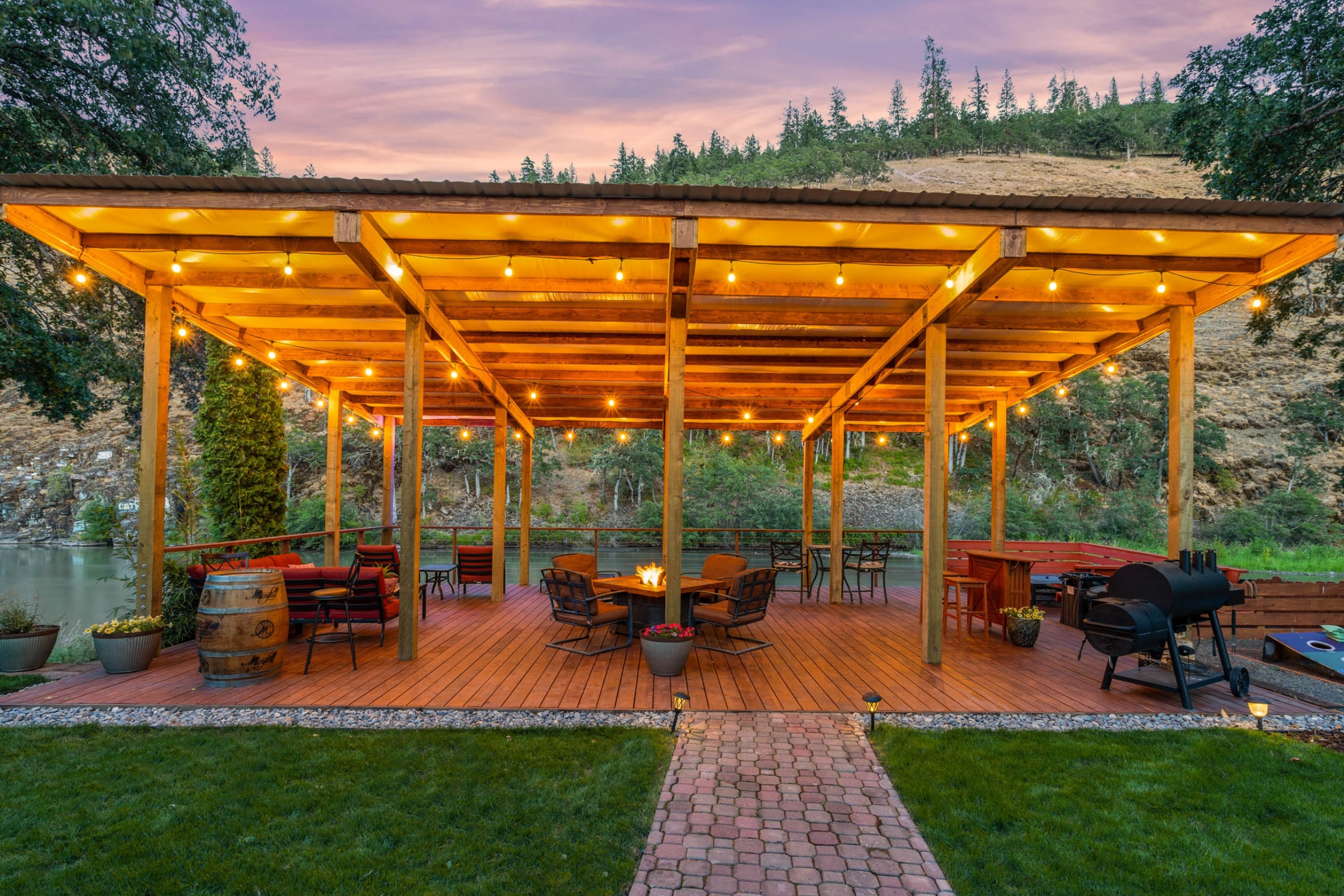 A patio with a fire pit and seating for many people.