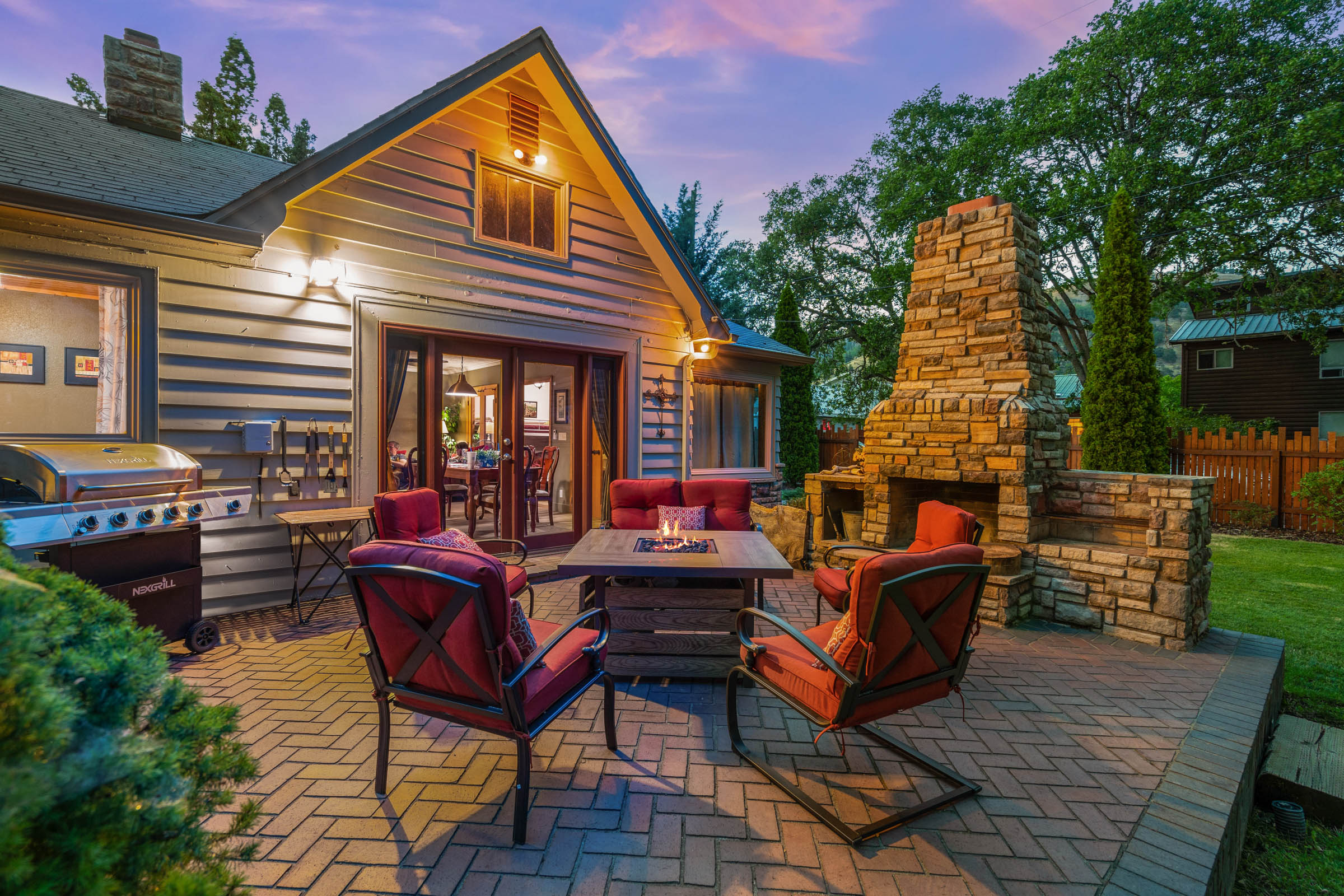 A patio with chairs and a table in the middle of it