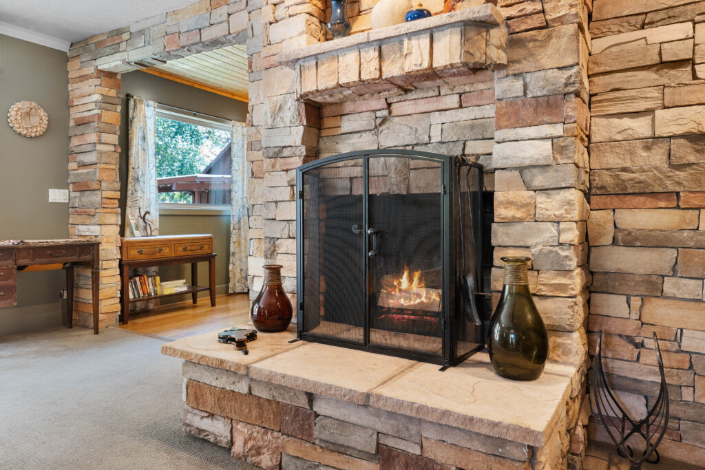 A fireplace with two vases on the mantle.