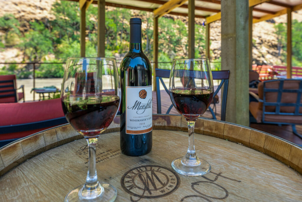 Two glasses of wine and a bottle on top of a table.