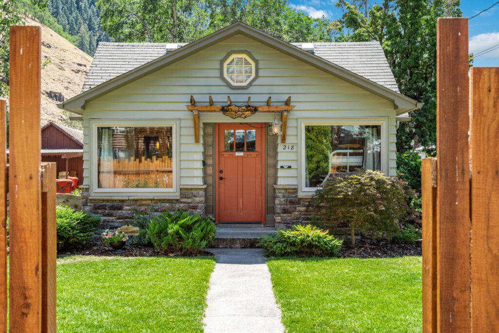 A small house with a clock on the front door.