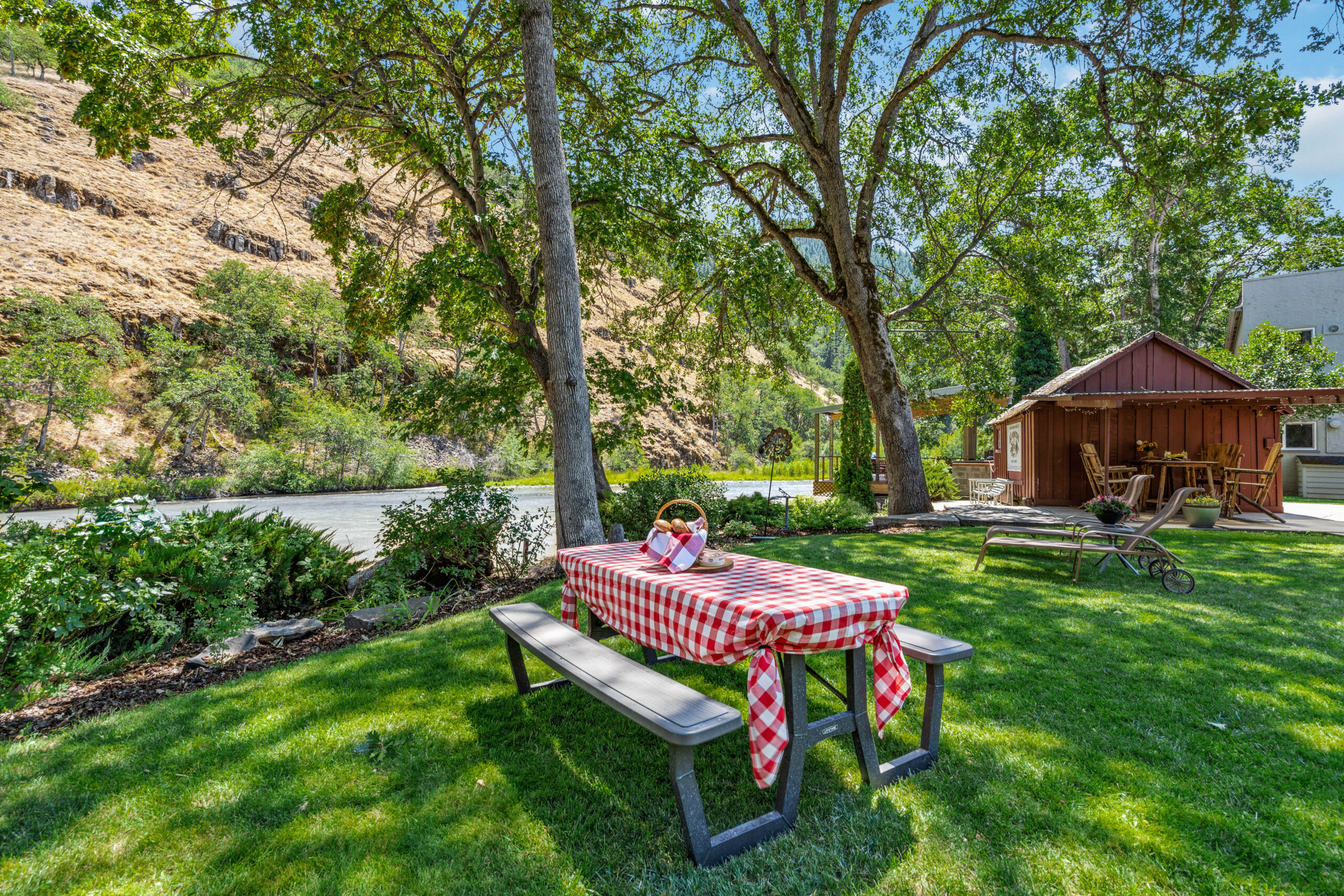 A picnic table with a red and white checkered tablecloth.