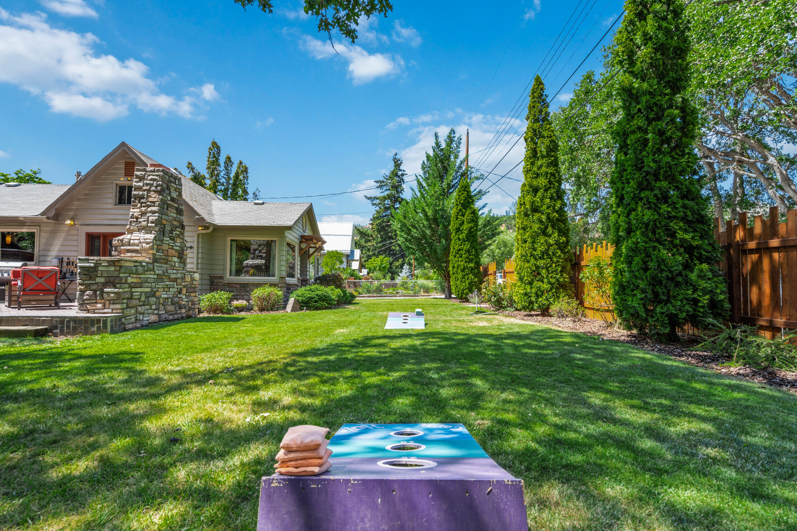 A table in the middle of a yard with trees and houses.