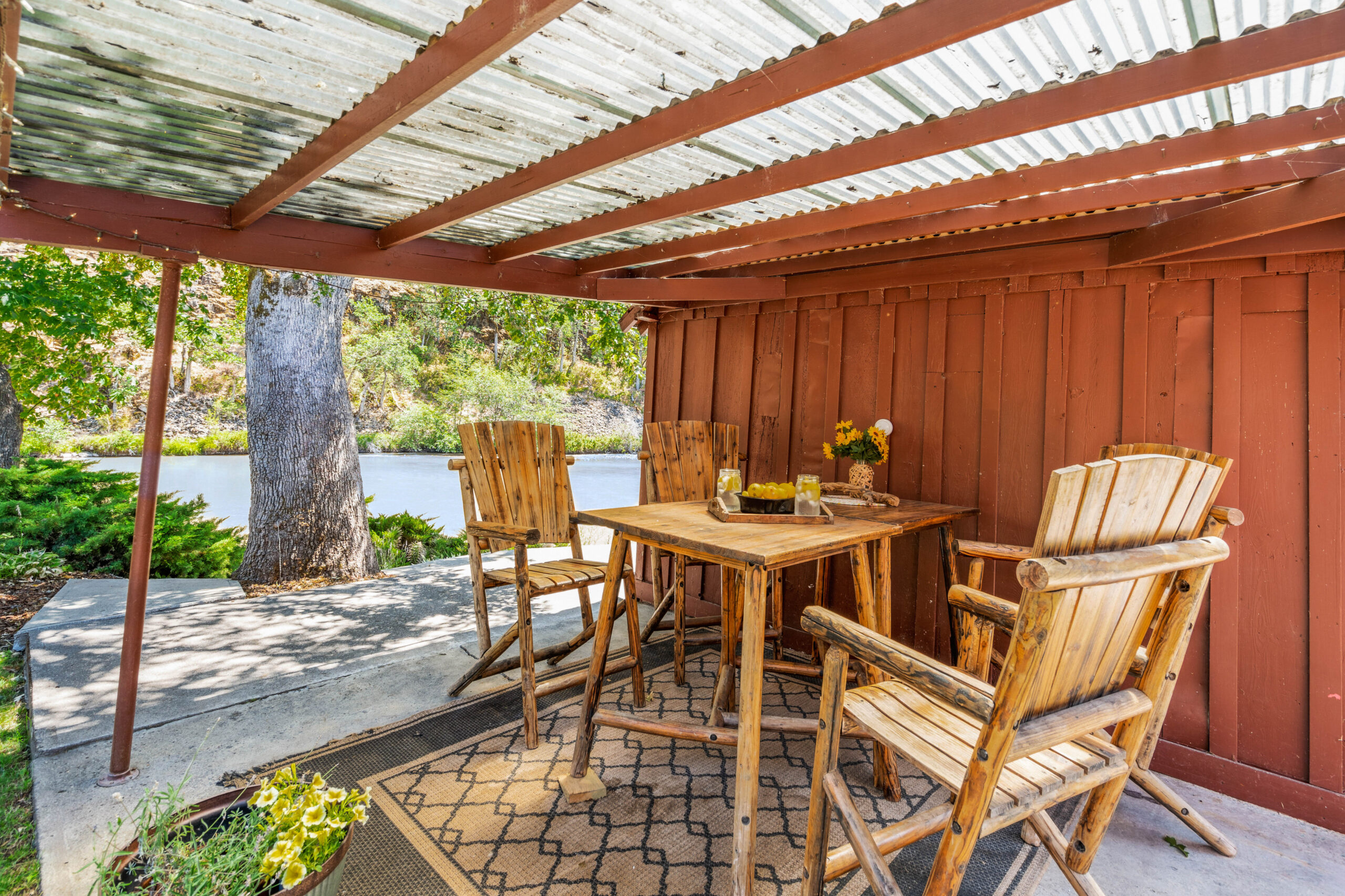 A wooden table and chairs under an awning.