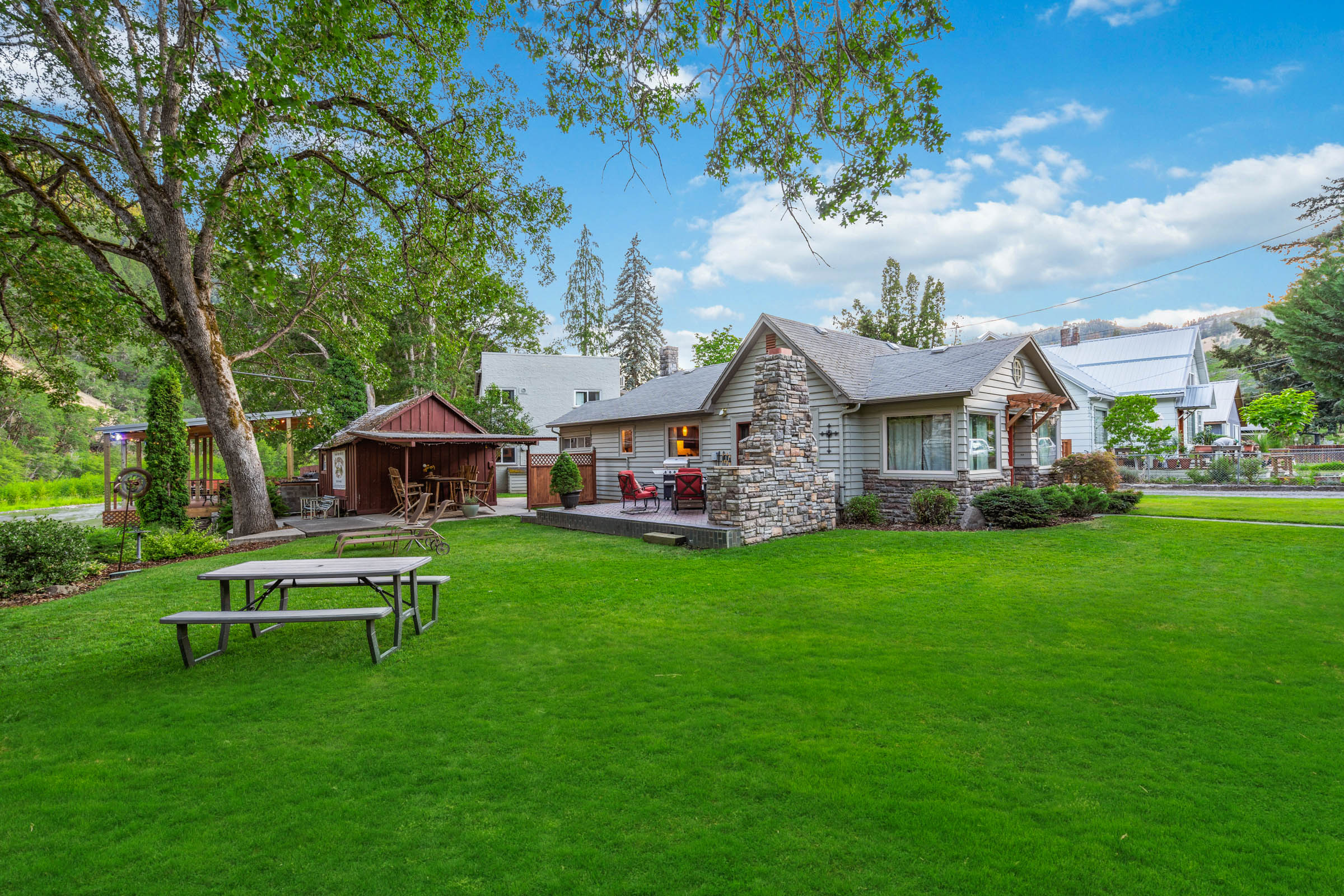 A large yard with picnic tables and a gazebo.