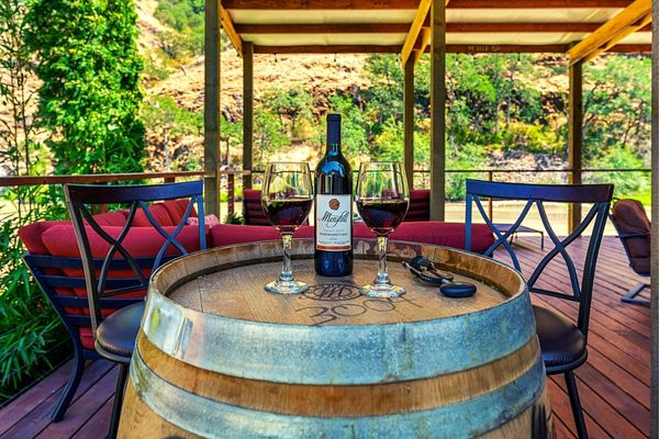 A bottle of wine sitting on top of a barrel.