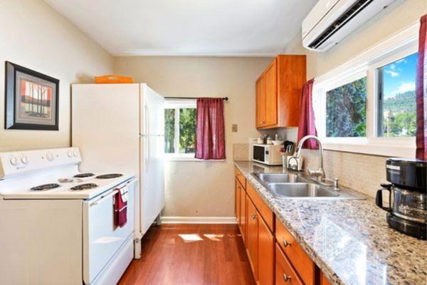 A kitchen with wooden floors and white appliances.