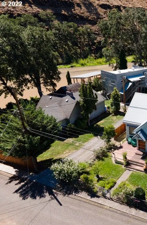 A view of houses from above, with trees in the background.