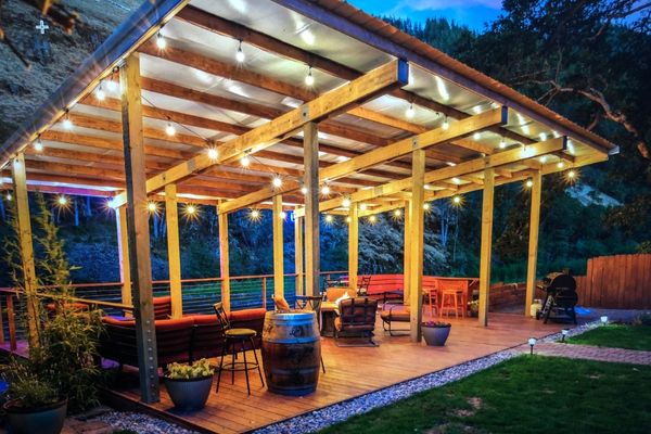 A patio with lights and furniture on the ground.