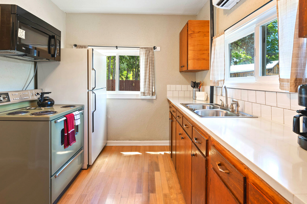 A kitchen with wood floors and white counters.