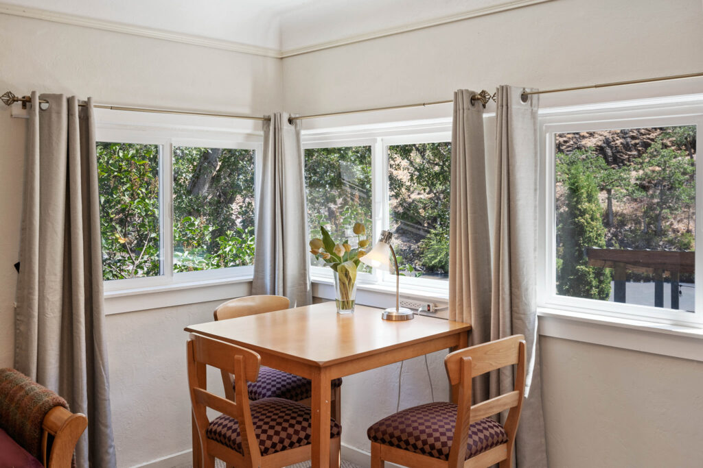 A small table with two chairs in front of a window.