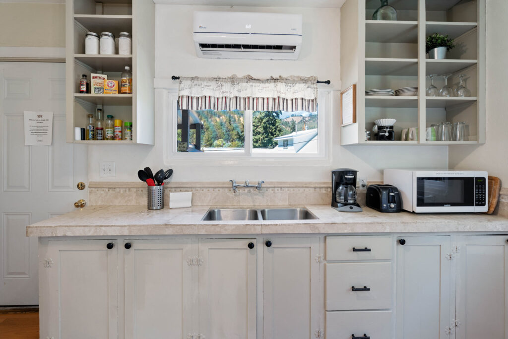 A kitchen with white cabinets and appliances in it