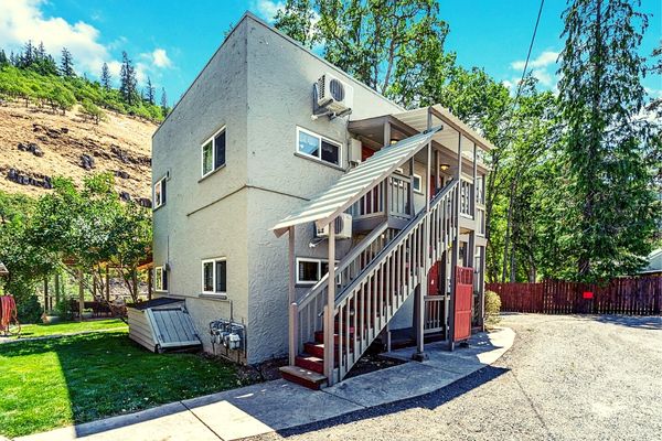 A white building with stairs going up the side.